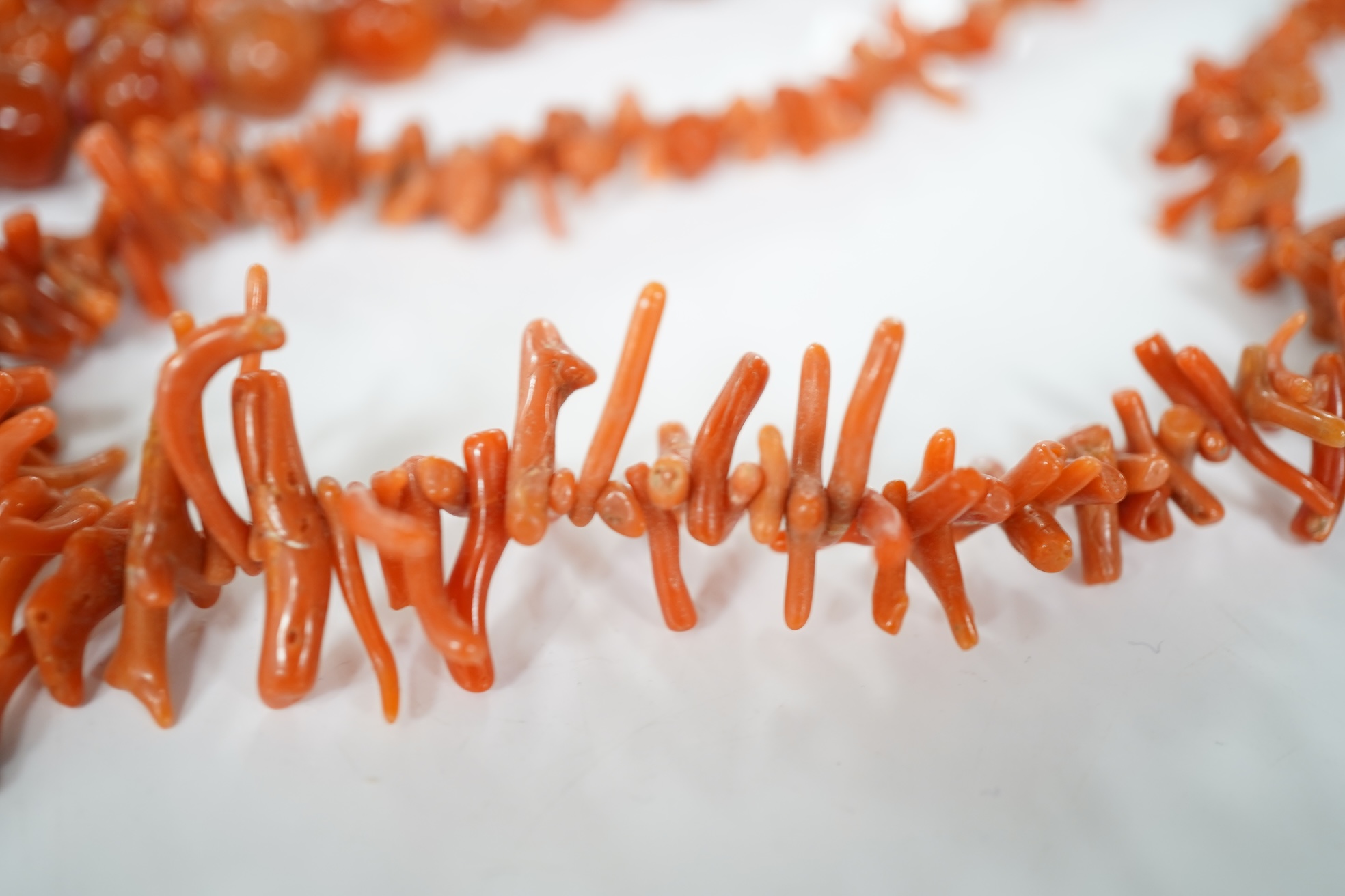 A micromosaic brooch and a group of bead necklaces, comprising: a micromosaic brooch depicting the Forum, length 4.6cm; together with a carnelian bead necklace; a coral branch necklace; and a green glass bead necklace